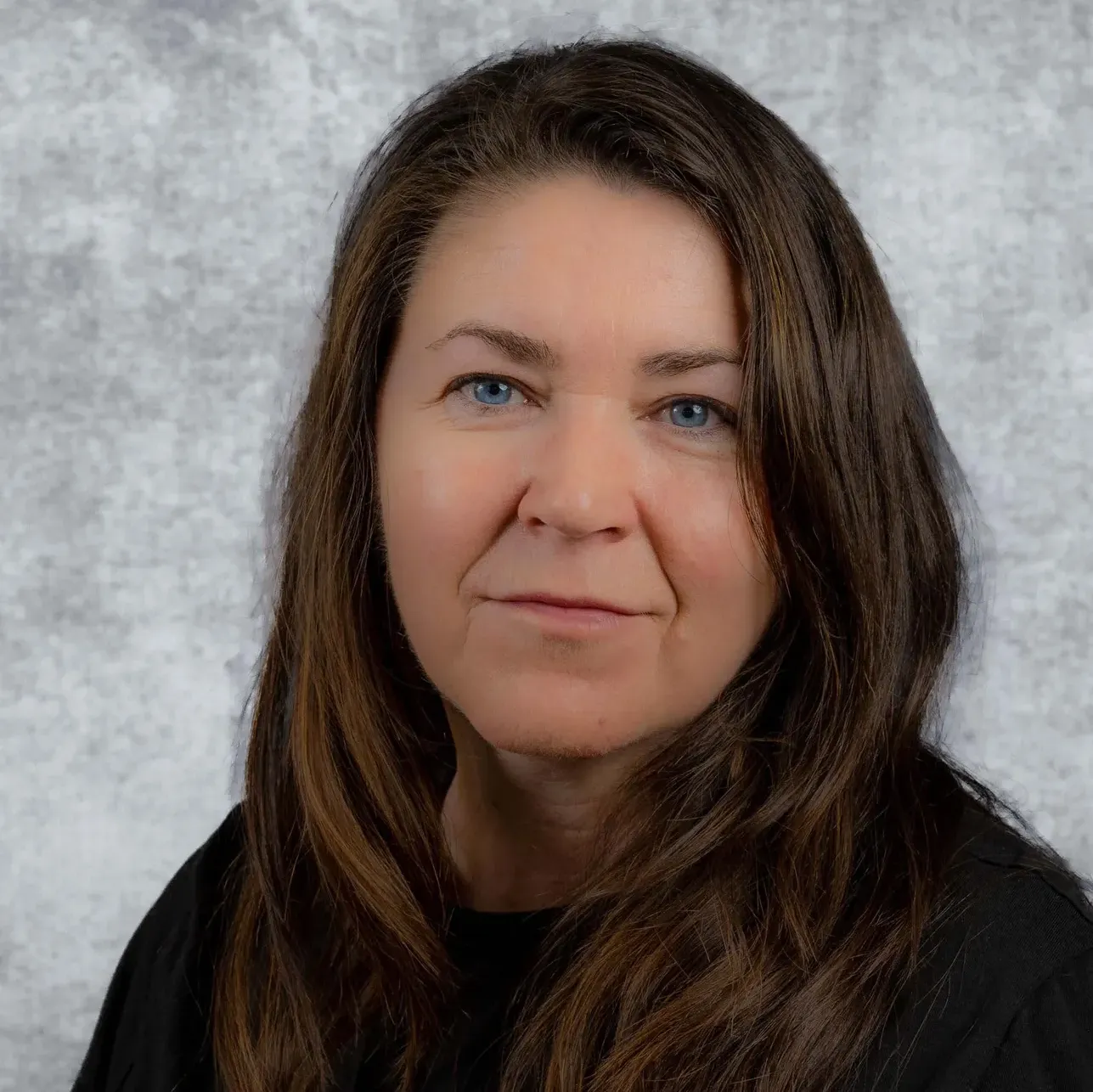 Woman's face with blue eyes and long brown hair.